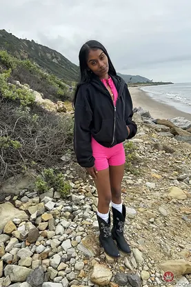 Watch petite Indian babe Fae Love tease and flash her clean-shaven pussy up close on the beach