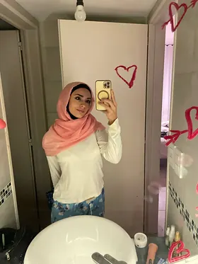 Watch her switch between hijab and lingerie while getting off in solo action on the couch