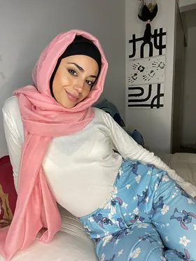 Watch her switch between hijab and lingerie while getting off in solo action on the couch