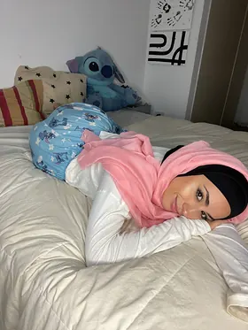 Watch her switch between hijab and lingerie while getting off in solo action on the couch