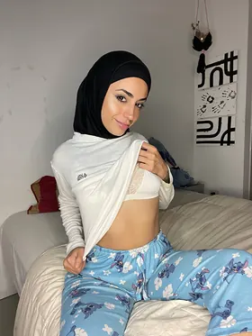 Watch her switch between hijab and lingerie while getting off in solo action on the couch
